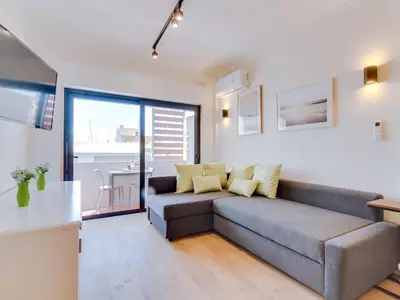 a living room with a couch and a kitchen at AL - Apartamento Mira Atlantico in Quarteira