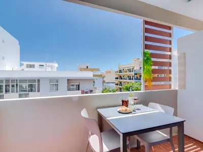 a table and chairs on the balcony of a apartment at AL - Apartamento Mira Atlantico in Quarteira