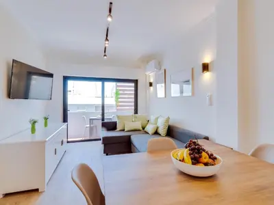 a kitchen and living room with a bowl of fruit on a table at AL - Apartamento Mira Atlantico in Quarteira