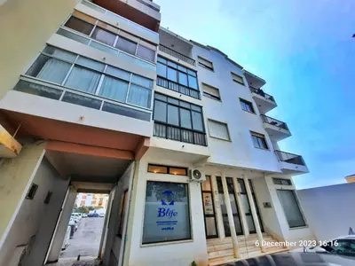 a white building with a blue sign on it at Blife Anya private apartment in Faro