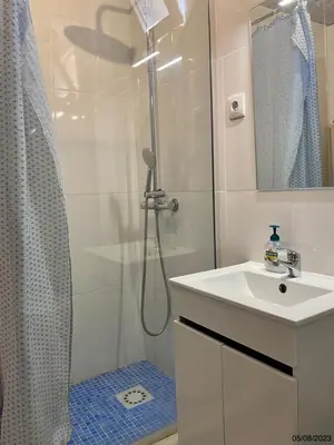 a white bathroom with a shower and a sink at Blife Julya private apartment in Faro