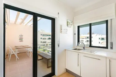 a kitchen with a view of a dining room with a table at Salgados Retreat -Steps from the Beach at Homesbyfc in Guia