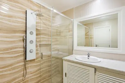 a bathroom with a sink and a glass shower at Salgados Retreat -Steps from the Beach at Homesbyfc in Guia