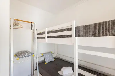 a bedroom with two bunk beds and a ladder at Salgados Retreat -Steps from the Beach at Homesbyfc in Guia