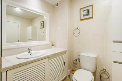 a bathroom with a toilet and a sink and a mirror at Salgados Retreat -Steps from the Beach at Homesbyfc in Guia