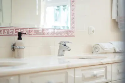 a bathroom with two sinks and a mirror at Villa Mia - Vale do Lobo in Vale do Lobo