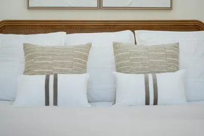 a white bed with white pillows and a wooden headboard at Villa Mia - Vale do Lobo in Vale do Lobo