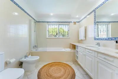 a bathroom with a toilet and a tub and a sink at Villa Mia - Vale do Lobo in Vale do Lobo