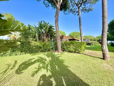 a swing in the middle of a yard with palm trees at Vilamoura Amazing Villa 2 With Pool by Homing in Vilamoura