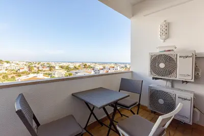 a white bedroom with a bed and a window at Sea House Apartment - Private Condo with 4 Pools, Jacuzzi & Tennis Court in Albufeira