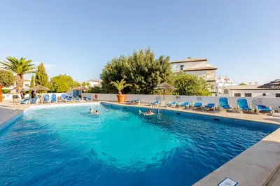 a patio with tables and chairs next to a swimming pool at Sea House Apartment - Private Condo with 4 Pools, Jacuzzi & Tennis Court in Albufeira