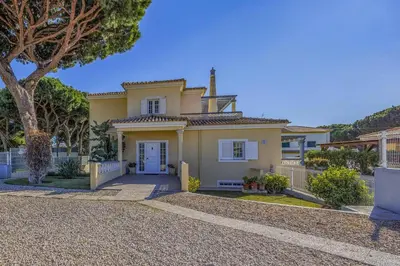 a large yellow house with a tree in front of it at Villa Caly by Villa Plus in Roja- Pé