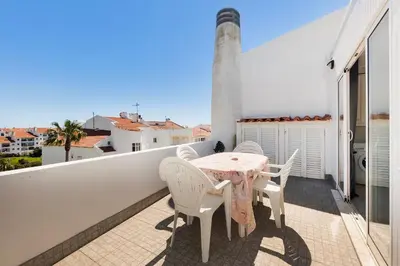 a small kitchen with a white refrigerator in a room at Let the sun come in - walking to the beach by Algarve Dream Holidays in Albufeira