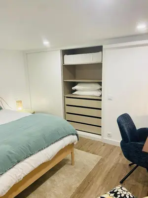 a bedroom with a bed and a blue chair at Confort à Loulé in Loulé