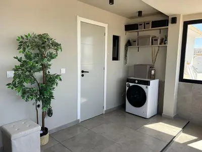 a laundry room with a washing machine and a door at Blue Coast Penthouse T4 in Quarteira