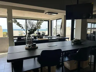 a kitchen with a large table with chairs and windows at Blue Coast Penthouse T4 in Quarteira