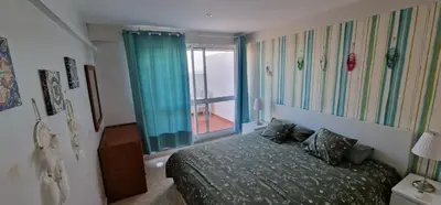 a bedroom with a bed and a large window at Apartamento Gaivotas in Albufeira