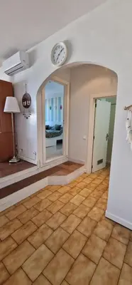 an empty living room with a clock on the wall at Apartamento Gaivotas in Albufeira