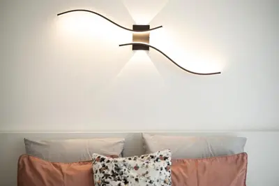 a lamp above a couch with pillows at LIA - Quarteira in Quarteira