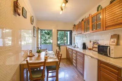 a kitchen with wooden cabinets and a table and chairs at Albufeira INN - Av Liberdade T2 in Albufeira