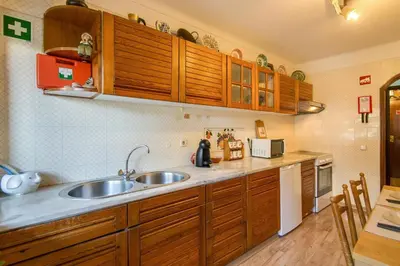 a kitchen with wooden cabinets and a sink at Albufeira INN - Av Liberdade T2 in Albufeira