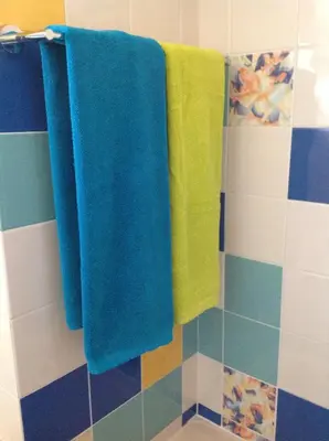 three towels hanging on a rack in a bathroom at Marina de Albufeira - Apartamentos Turísticos da Orada in Albufeira