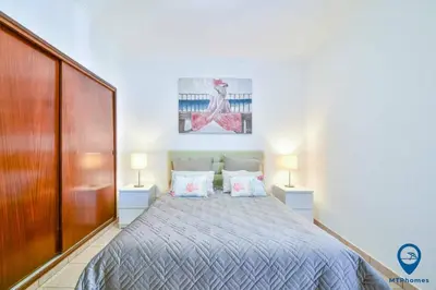 a bedroom with a bed with two night stands and two lamps at Praia Mar by MTPhomes in Quarteira