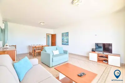 a living room with a couch and a tv and a table at Praia Mar by MTPhomes in Quarteira