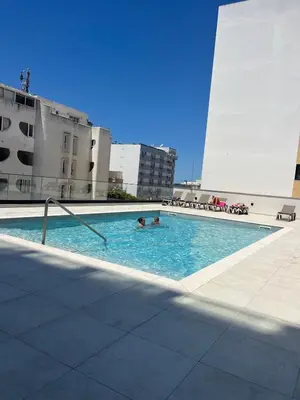 a swimming pool on a building with two people in it at NEW Apartment, Sea Front & Pool in Quarteira