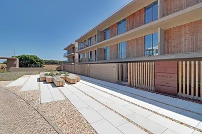 a building with benches in front of it at New Beach Apartment in Quarteira