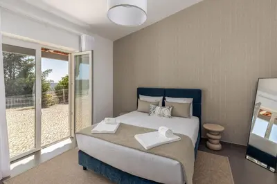 a bedroom with a large bed and a balcony at Villa e5 in Tunes