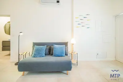 a living room with a couch and a kitchen at Maria Sardinha by MTPhomes in Ferreiras