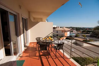 a balcony with chairs and a table with fruit on it at Apartamento Albufeira- Descobrimentos in Albufeira