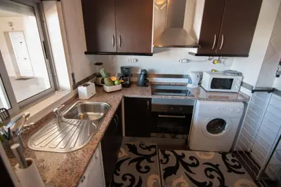 a small kitchen with a sink and a washing machine at Apartamento Albufeira- Descobrimentos in Albufeira
