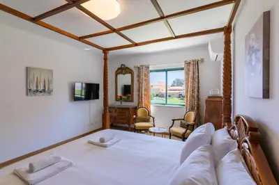 a bedroom with a four poster bed and a chair at #310 Families Only - Jardins de Santa Eulalia 03 in Branqueira