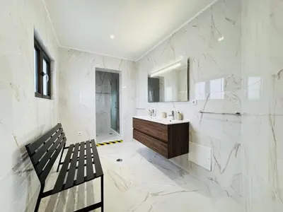a white bathroom with a bench and a sink at Vilamoura Summer Villa 2 With Pool by Homing in Vilamoura