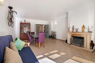 a living room with a table and a fireplace at Habemus Domu Albufeira in Albufeira