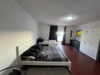 a room with two beds and a kitchen in it at Casa Lopes in Albufeira