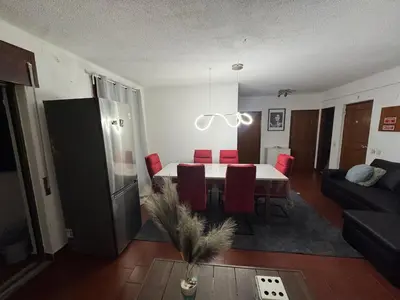 a living room with a black couch and red chairs at Casa Lopes in Albufeira