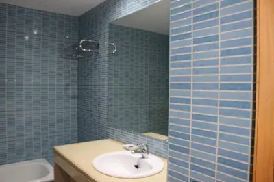 a blue tiled bathroom with a sink and a mirror at Spacious apartment in Albufeira 200 m² with shared pool in Albufeira