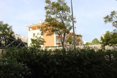 a building in the background with trees in the foreground at Spacious apartment in Albufeira 200 m² with shared pool in Albufeira