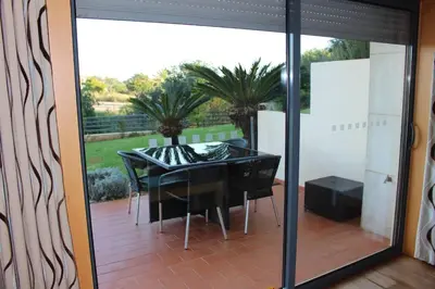 a glass door with a table and chairs on a patio at Spacious apartment in Albufeira 200 m² with shared pool in Albufeira