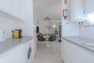 a kitchen with a washer and dryer and a table at #351 Edificio Marina 1 D by Home Holidays in Páteo