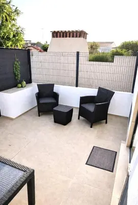 a patio with chairs and tables on a building at Casa luz e conforto-Casa 20 in Almancil