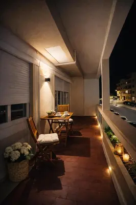 a balcony with a table and chairs at night at Dream House in Loulé