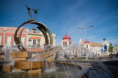 a fountain in the middle of a city with buildings at Dream House in Loulé