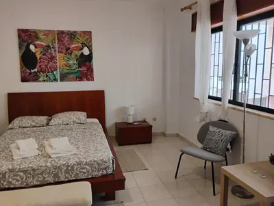 a bedroom with a bed and a chair in it at Cozy studio in Quarteira in Quarteira