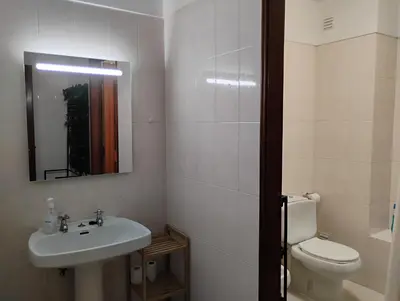 a bathroom with a sink and a toilet and a mirror at Cozy studio in Quarteira in Quarteira
