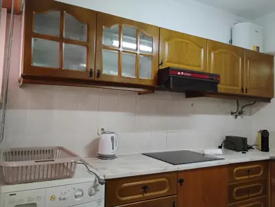 a kitchen with wooden cabinets and a counter top at Cozy studio in Quarteira in Quarteira