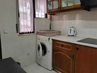 a kitchen with a washing machine and a sink at Cozy studio in Quarteira in Quarteira